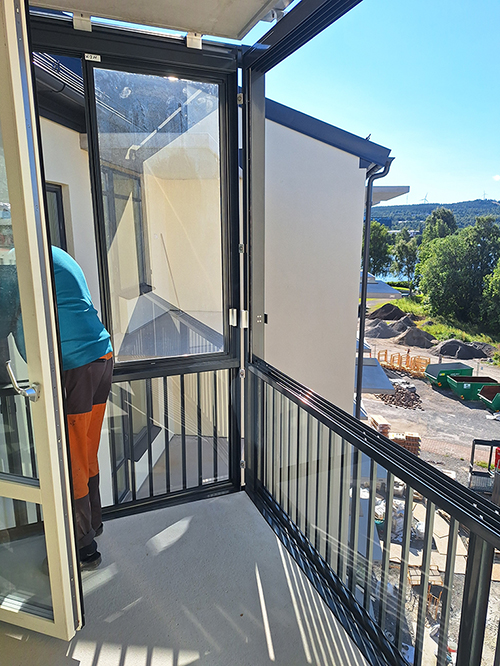 Inglasning monteras på balkong
