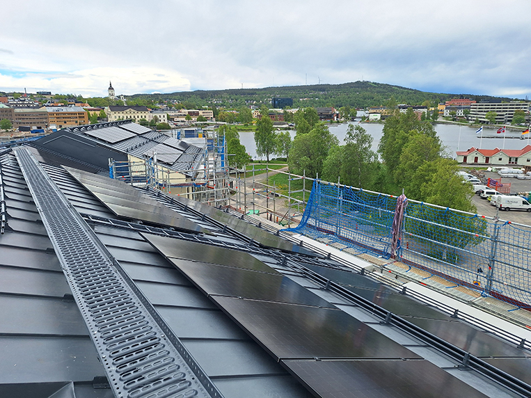 Vy över tak med solceller, i bakgrunden domkyrkan, Nattviken och Vårdkasen